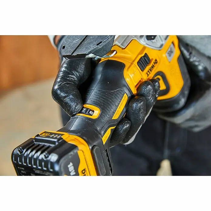 DeWalt XR 18V Akku-Pendelhubstichsäge DCS335N-XJ - 18 V, Ohne Akku, Leerlaufhubzahl: 1.000 /min - 3.200 /min - Detailaufnahme einer gelb-schwarzen DeWalt Akku-Blechschere in der Hand, die den hochwertigen, bürstenlosen Motor und die variable Geschwindigkeitseinstellung zeigt.