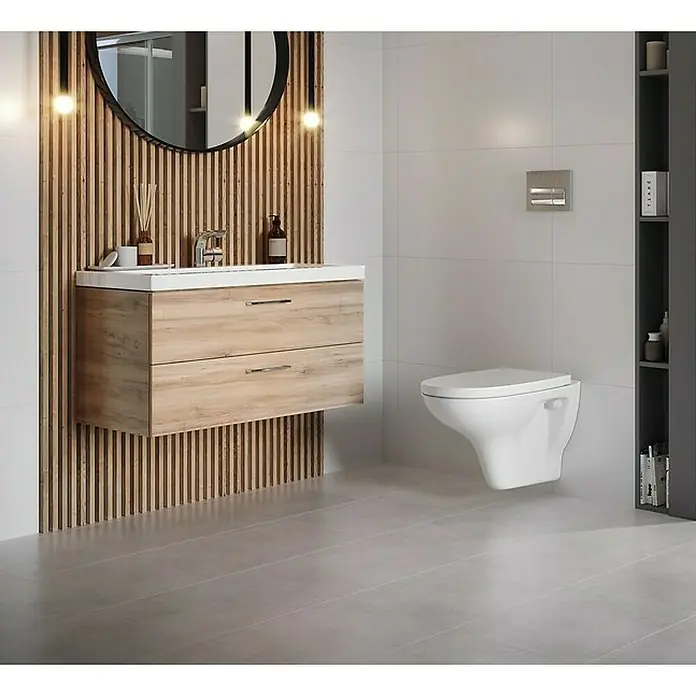 Wand-WC-Set Arteco - Spülrandlos, Ohne Spezialglasur, Spülform: Tief, WC Abgang: Waagerecht, Weiß - Modernes Badezimmer-Interieur mit hängendem Waschtischunterschrank in Holzoptik, einem runden Spiegel und einer wandhängenden Toilette.