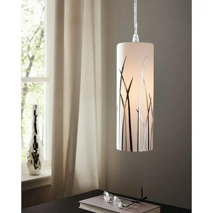 Eglo Lámpara colgante Rivato - 180 W, L x An x Al: 70,5 x 9 x 110 cm, Cromo, E27 - Primer plano de una elegante lámpara colgante cilíndrica con un patrón decorativo, que cuelga sobre una mesa con gafas.