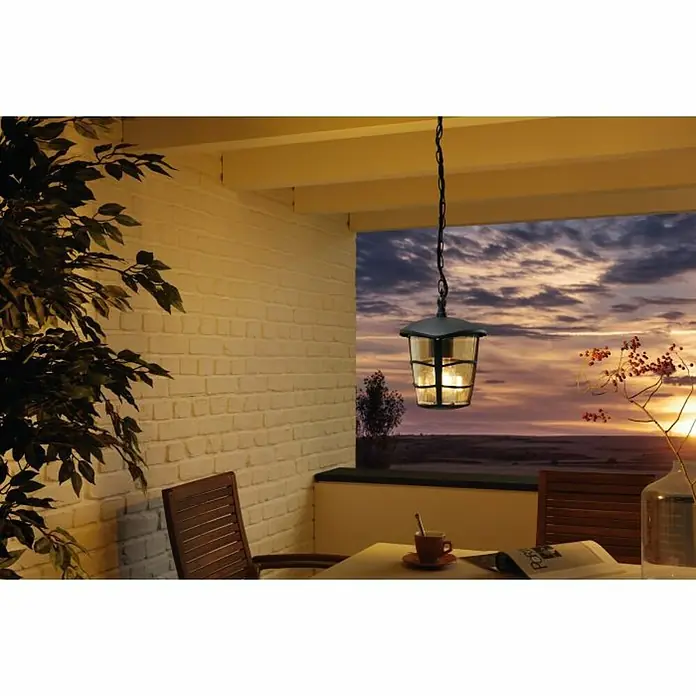Eglo Aloria Lámpara colgante - 60 W, Altura: 68,5 cm, Negro, E27 - Una luz colgante de exterior con marco negro y paneles de vidrio transparente cuelga sobre una mesa y sillas en un patio.