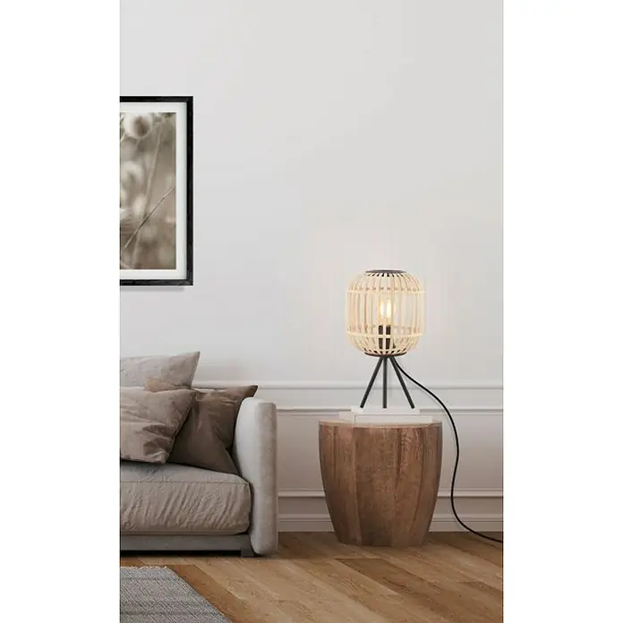 Eglo Bordesley Lámpara de sobremesa - 28 W, Ø x Al: 21 x 40 cm, Marrón claro, E27 - Una moderna lámpara de noche de ratán con una base trípode negra, que emite un brillo cálido en un espacio habitable elegante.