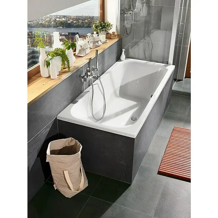 Camargue Badewanne Hermosa - 180 x 80 cm, Sanitäracryl, Weiß - Eine moderne Badezimmeransicht mit einer strahlend weißen Badewanne, stilvollen Armaturen und dekorativen Elementen auf der Fensterbank.