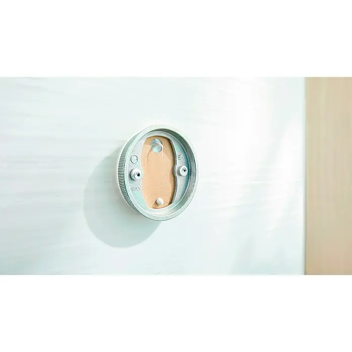 Tesa Montage-Set BK43-2 - 2 -tlg., Geeignet für: Badutensilien - Nahaufnahme einer runden, silbernen Thermostat-Wandhalterung an einer weißen Wand.