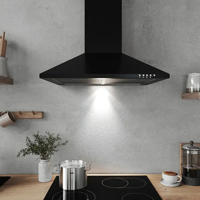 Respekta Kaminhaube Karena - Breite: 60 cm, Max. Gebläseleistung Abluftbetrieb: 308,8 m³/h, Schwarz - Einbau-Dunstabzugshaube in Schwarz über einem Kochfeld mit Topf, Kaffeetasse und Dekoration für eine moderne Küche.