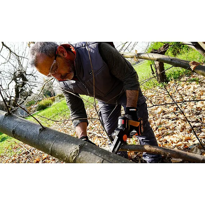 Worx PowerShare 20V Akku-Astsäge WG325E.9 - 20 V, Li-Ionen, Ohne Akku, Schwertlänge: 12 cm - Mann schneidet einen Baumstamm mit einer WORX Akku-Kettensäge. Die WORX Kettensäge ist ideal zum Beschneiden und für leichte Schneidearbeiten im Garten.