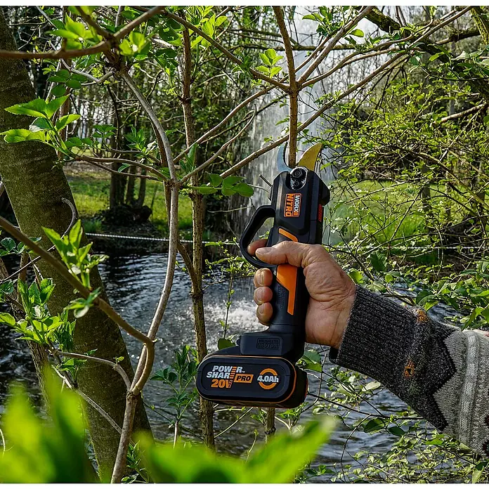 Worx PowerShare 20V Tijeras para podar de batería WG330E.9 - 20 V, Sin batería, Grosor de rama máx.: 25 mm - Primer plano de una podadora inalámbrica Worx Nitro recortando una rama, ideal para jardinería.