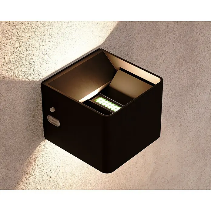 Lavida Aplique de pared con batería Lucca - L x An x Al: 10 x 10 x 8 cm, 1,2 W, Negro, Blanco cálido - Primer plano de una lámpara de pared moderna en forma de cubo con LEDs verdes montada en una pared texturizada, creando un ambiente elegante.