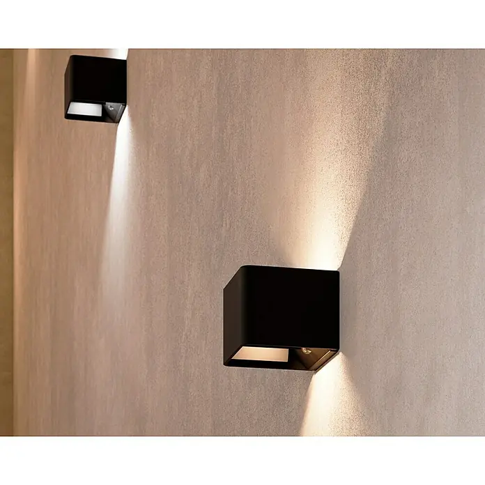 Lavida Akku-Wandleuchte Lucca - L x B x H: 10 x 10 x 8 cm, 1,2 W, Schwarz, Warmweiß - Wandleuchten aus schwarzem Metall werfen warmes Licht an eine strukturierte Wand und schaffen eine moderne, stimmungsvolle Atmosphäre.