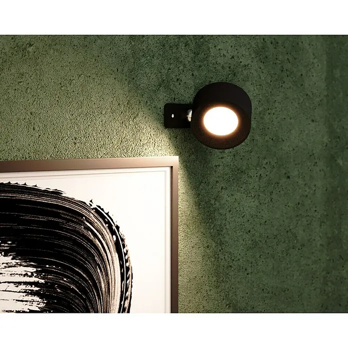 Lavida Akku-Wandleuchte Novara - L x B x H: 9,25 x 7,6 x 4,5 cm, 2 W, Schwarz, Mehrfarbig, Rund - Nahaufnahme einer modernen schwarzen Wandleuchte, die ein Kunstwerk beleuchtet. Die Wandleuchte hat ein elegantes, zylindrisches Design.