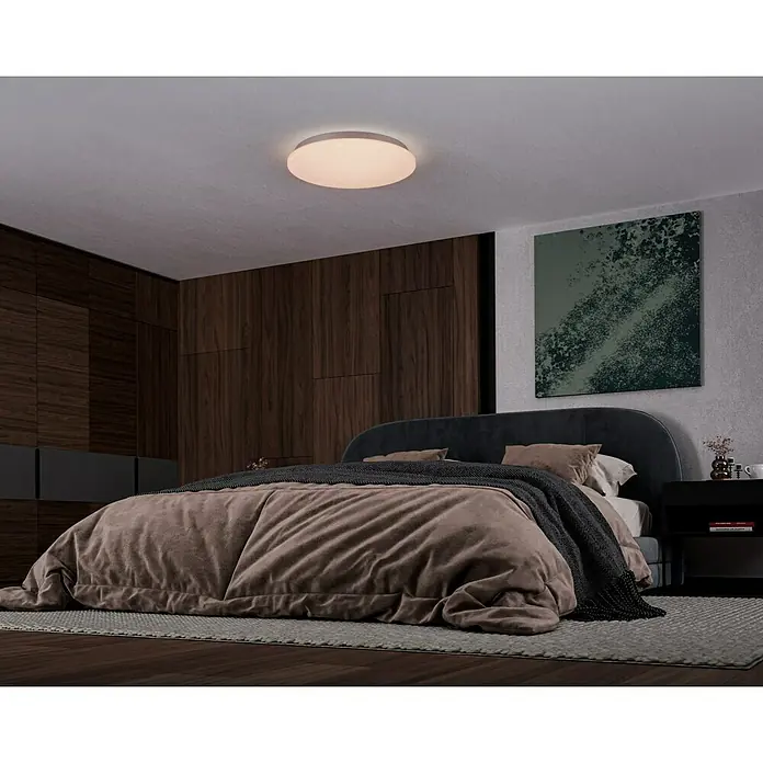 Reality Leuchten LED-Deckenleuchte Kato Starlight - 27 W, L x B x H: 60 x 60 x 12 cm, Weiß, Mehrfarbig - Ein modernes Schlafzimmer mit einer runden Deckenleuchte, die warmes Licht spendet und eine gemütliche Atmosphäre schafft. Elegantes Design und sanfte Beleuchtung.