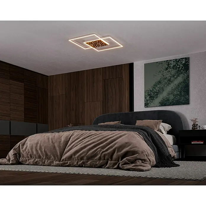 Paul Neuhaus LED-Deckenleuchte YUKI - 57 W, L x B x H: 67 x 67 x 5 cm, Stahl, Mehrfarbig - Dieses Schlafzimmer verfügt über eine moderne quadratische Deckenleuchte, ein bequemes Bett mit Tagesdecke und einen Nachttisch. Die Lampe spendet warmes Licht.