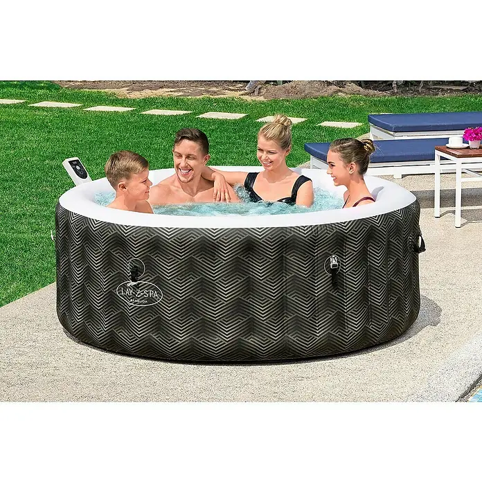 Bestway Lay-Z-Spa Mobil-Whirlpool Barbuda AirJetØ x H: 180 x 66 cm, Grau, 669 l - Ein Lay-Z-Spa Whirlpool mit geometrischem Muster, in dem sich vier Personen entspannen, steht auf einer Terrasse neben einem Rasen.