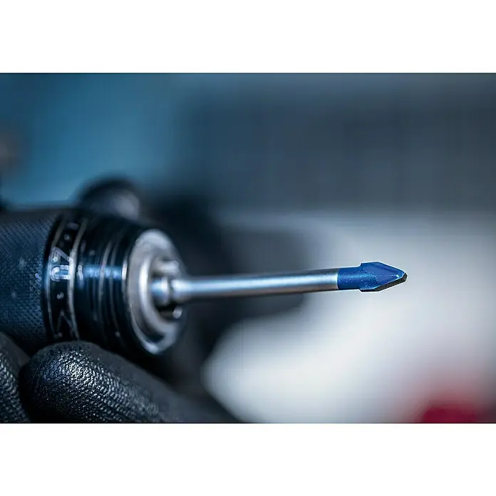 Bosch Professional Expert Bohrer-Set EXPERT HEX-9 HardCeramic5 Stk., Durchmesser Bohrer: 6 mm - Nahaufnahme eines blauen Glasbohrers, der in einer Bohrmaschine befestigt ist und von einer Hand mit Arbeitshandschuh gehalten wird.