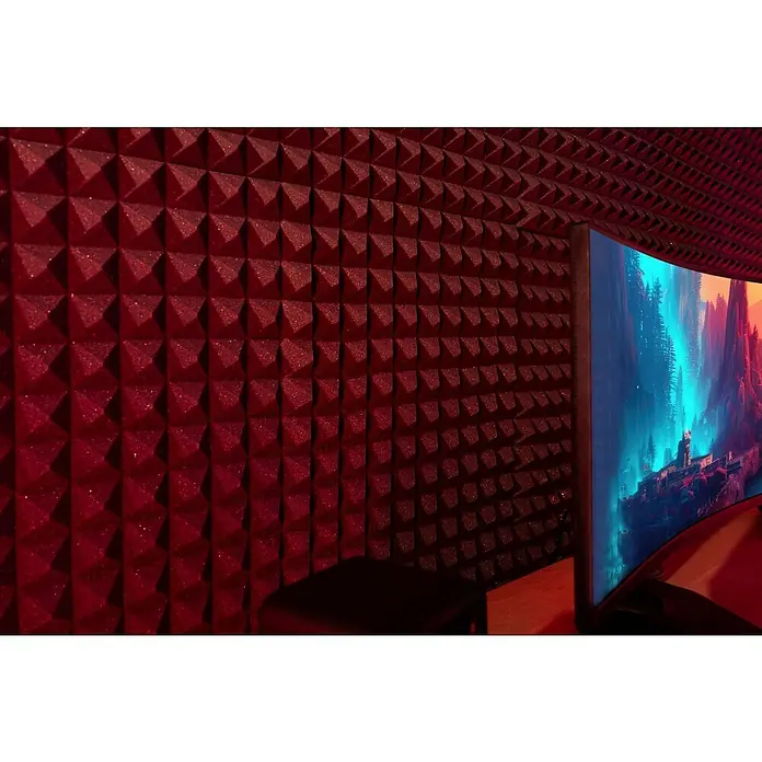 Noppenschaum Akupur - Pyramide, 100 x 50 x 4 cm, PU-Schaum - Nahaufnahme eines modernen Curved-Monitors vor einer Wand mit roter Akustikschaumstoff-Pyramidenstruktur für ein verbessertes Klangerlebnis.
