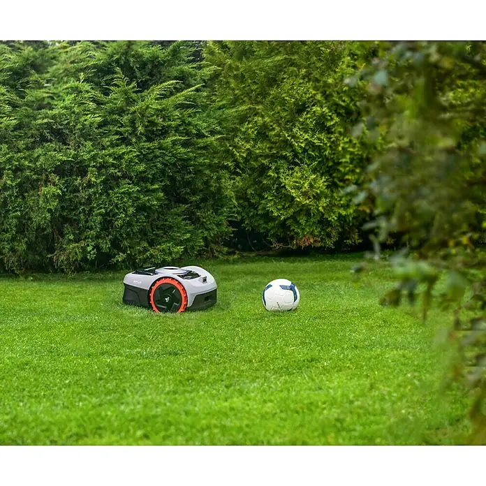 Segway Mähroboter Navimow i105E - 500 m², Schnittbreite: 18 cm, Satellitengestützte Navigation, RTK - Rasenmähroboter und Fußball auf dem grünen Rasen, umgeben von üppigem Grün.