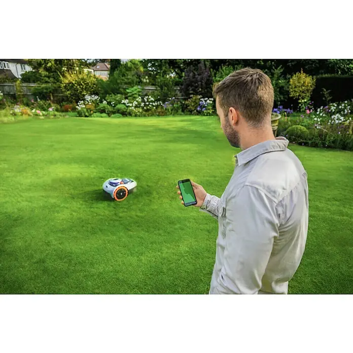 Segway Mähroboter Navimow i105E - 500 m², Schnittbreite: 18 cm, Satellitengestützte Navigation, RTK - Ein Mann bedient einen Rasenmähroboter mit seinem Smartphone in einem gepflegten Garten. Moderne Gartentechnik für bequeme Rasenpflege.