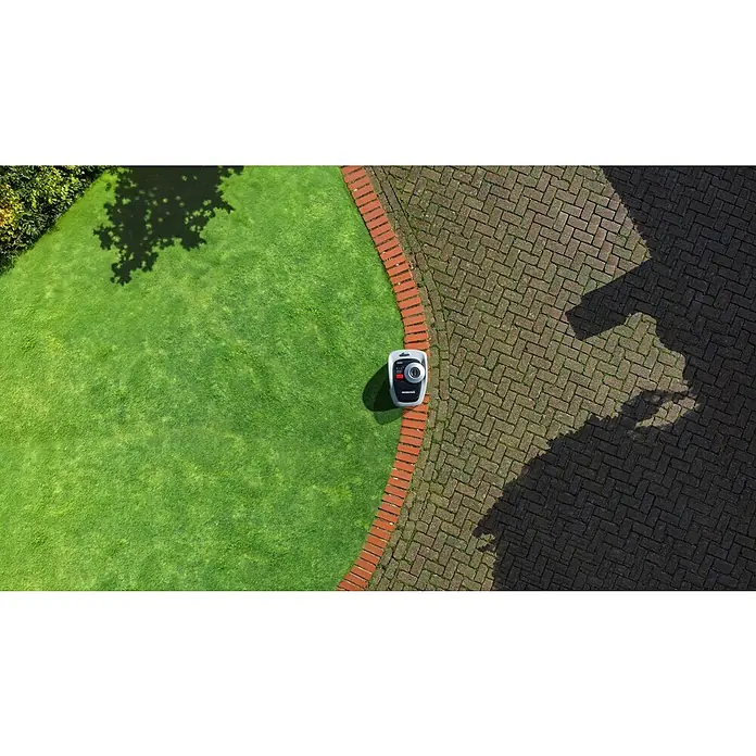 Segway Mähroboter Navimow i105E - 500 m², Schnittbreite: 18 cm, Satellitengestützte Navigation, RTK - Draufsicht eines Robotermähers auf Rasen neben einer Pflasterfläche. Der Mähroboter ist das Hauptaugenmerk des Bildes.