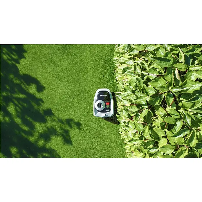 Segway Mähroboter Navimow i105E - 500 m², Schnittbreite: 18 cm, Satellitengestützte Navigation, RTK - Intelligenter Rasenmäher von NaviMow, parkend auf einem gepflegten Rasen neben üppigem Grün, bereit für die Rasenpflege mit Präzision.