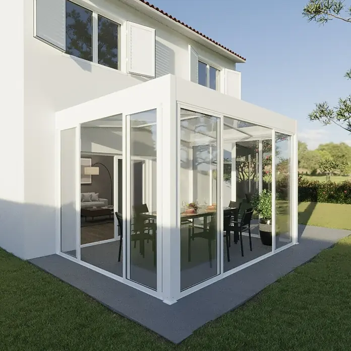 Wismar-NFI Wintergarten - 500 x 300 cm, Satteldach, Polycarbonat, Verkehrsweiß, Milchig Weiß - Bild eines modernen Wintergartens mit Glaswänden und einem weißen Rahmen, der an ein Haus angebaut ist, mit Blick auf einen Esstisch.