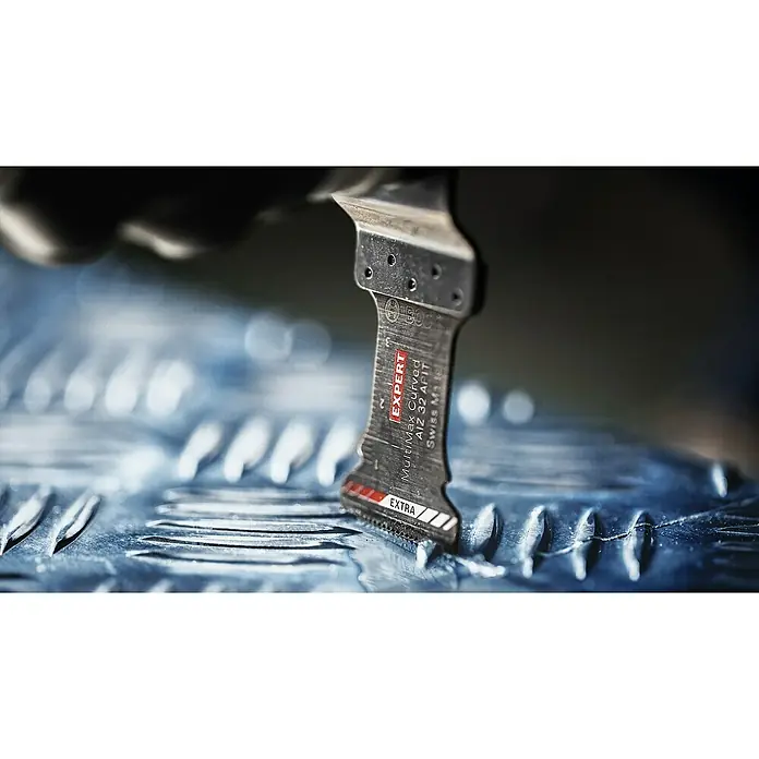 Bosch Expert Tauchsägeblatt MultiMax Precision - 40 x 32 mm - Nahaufnahme eines Bosch Expert MultiMax Curved AIZ 32 AFIT Sägeblatts beim Schneiden eines Metallstücks.