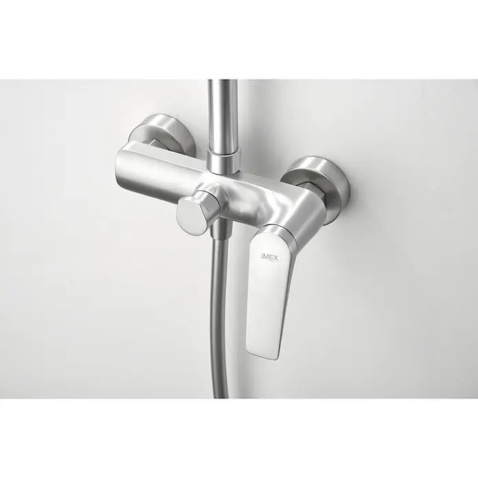 Imex Delos Sistema de ducha - Grifo monomando, Acero - Primer plano de un elegante grifo de ducha IMEX de acero inoxidable montado en una pared blanca, que muestra un diseño moderno y alta calidad.