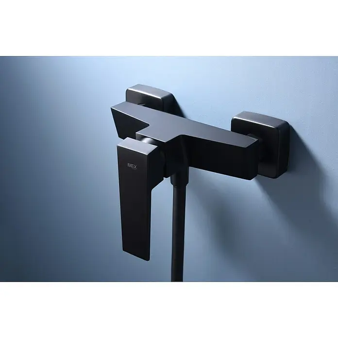 Imex Art Grifo monomando de ducha - Negro - Primer plano de un moderno mezclador de ducha IMEX negro mate con un diseño rectangular, montado en una pared azul pálido, que irradia elegancia.