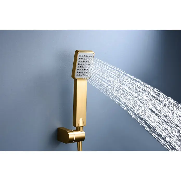 Imex Art Grifo monomando de ducha - Oro - Ducha de mano dorada con chorro de agua sobre una pared gris. Diseño de baño moderno y elegante con un accesorio de alta calidad.