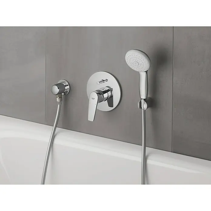 Grohe Tempesta 100 Handbrause - Anzahl Funktionen: 3 Stk., 9,5 l/min, Chrom - Nahaufnahme einer Grohe-Badewannenarmatur mit Handbrause und minimalistischem Design, montiert an einer grauen Wand über einer weißen Badewanne.