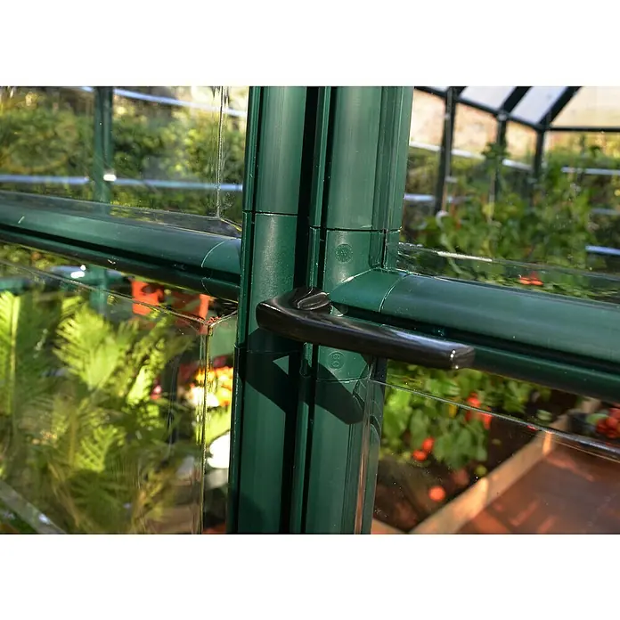 Palram – Canopia Invernadero Grand Gardener - Medidas ext. (An x Pr): 264,7 x 388,6 cm, Material de la pared lateral: Plástico, 0,8 mm, Verde - Primer plano de la ventana verde del invernadero con manija negra, que ofrece una visión del exuberante interior con plantas.