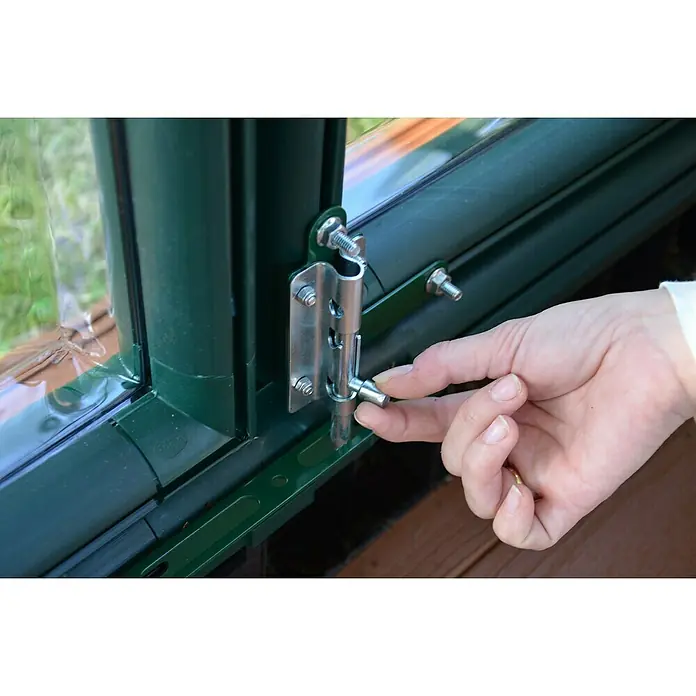 Palram – Canopia Invernadero Grand Gardener - Medidas ext. (An x Pr): 264,7 x 637,3 cm, Material de la pared lateral: Plástico, 0,8 mm, Verde - Primer plano de un cerrojo de ventana en un marco verde, accionado por una mano para asegurar el mecanismo de cierre.