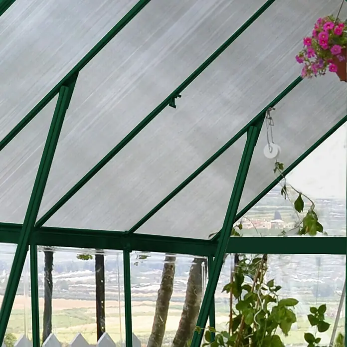 Palram – Canopia Invernadero Balance - Medidas ext. (An x Pr): 244 x 607 cm, 0,7 mm, Verde - Una vista al interior de un invernadero con estructuras verdes y plantas que crecen bajo los paneles translúcidos del techo.