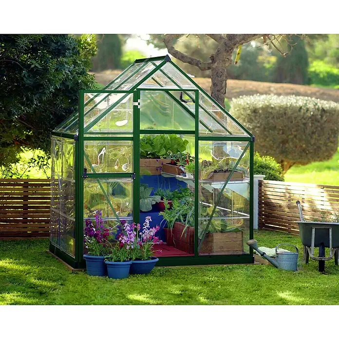 Palram – Canopia Invernadero Harmony - Medidas ext. (An x Pr): 185 x 126 cm, Verde, Área: 2,3 m² - La imagen muestra un invernadero verde lleno de plantas y flores en un jardín, lo que facilita la horticultura.