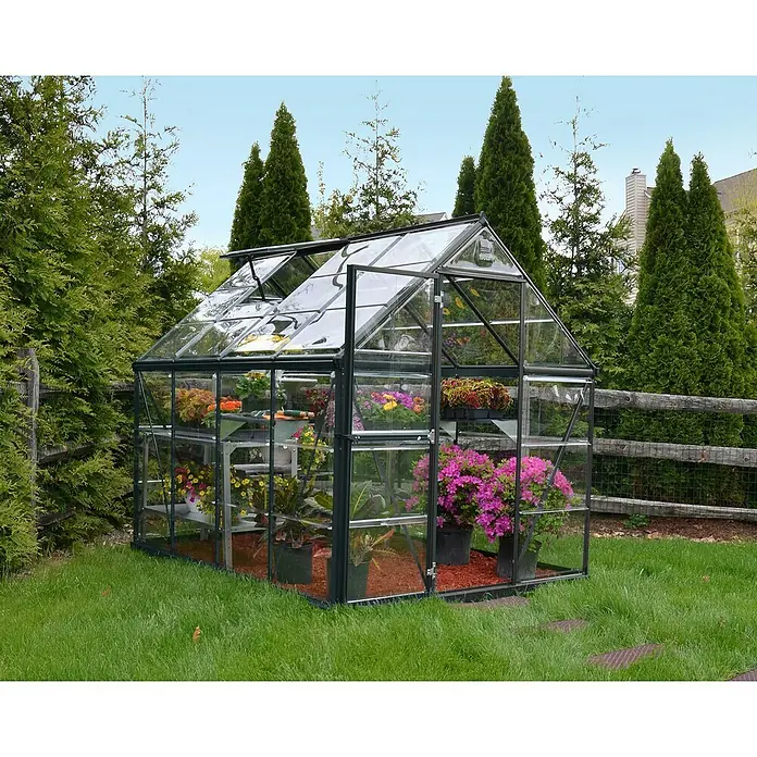 Palram – Canopia Invernadero Harmony - Medidas ext. (An x Pr): 185 x 247 cm, Gris, Área: 4,6 m² - Un invernadero de vidrio y metal se alza en el verde, lleno de flores y plantas coloridas.