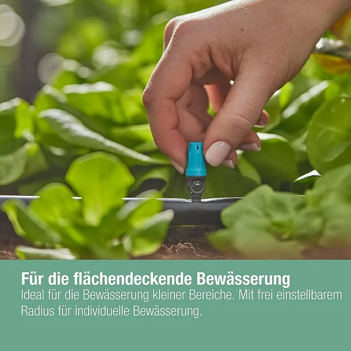 Gardena Micro-Drip Kleinflächendüse - 10 Stk., 1/2" x 13 mm - Nahaufnahme einer Hand, die einen blauen Bewässerungsregler an einem schwarzen Schlauch in einem Garten einstellt.