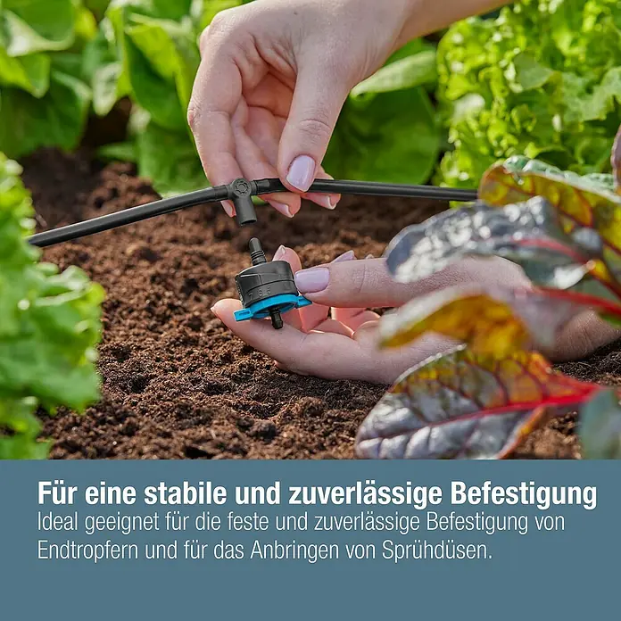 Gardena Micro-Drip T-Stück für Sprühdüsen & Endtropfer - 3/16" x 4,6 mm, 5 Stk. - Nahaufnahme von einer Hand, die ein Bewässerungssystem im Garten installiert.