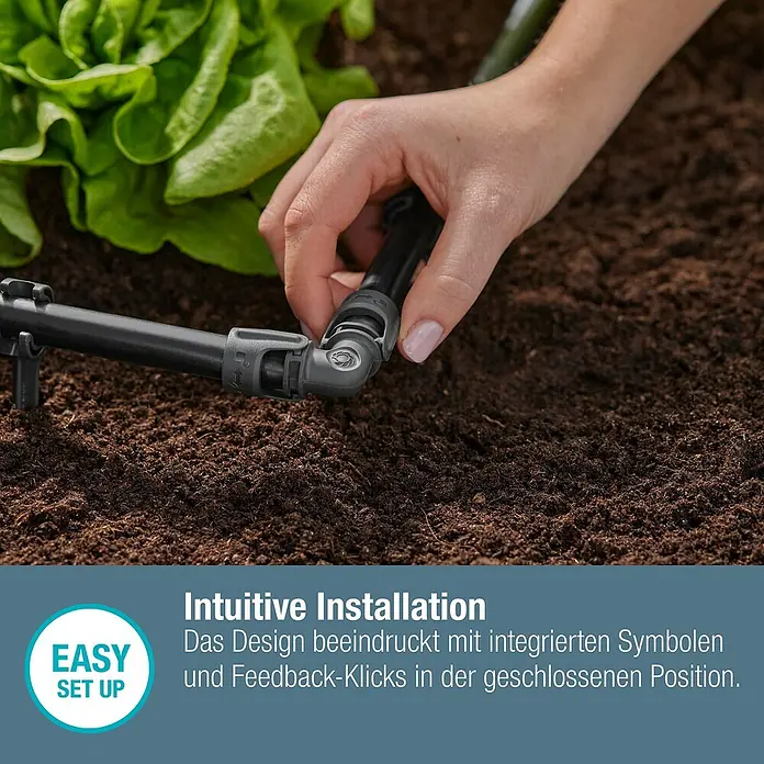 Gardena Micro-Drip L-Stück - 1/2" x 13 mm, 2 Stk. - Nahaufnahme einer Hand, die ein schwarzes Bewässerungssystem-Eckstück auf dunkler Erde montiert.
