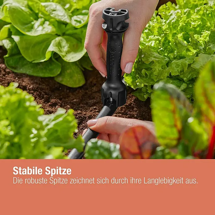 Gardena Micro-Drip Vorstecher - Passend für: Gardena Micro-Drip Artikel & Lochung des Verlegerohres, Kunststoff, Schwarz - Nahaufnahme einer Gardena Micro-Drip-System-Komponente, die in einem Gartenbeet installiert wird. Präzise Bewässerung für gesunde Pflanzen.