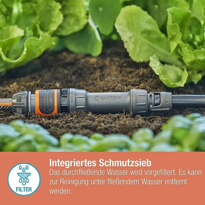 Gardena Micro-Drip Basisgerät 1000 - 1 Stk., Max. Wasserdurchfluss: 1.000 l/h - Nahaufnahme des GARDENA-Filters, der in einem Garten mit üppigem Grün auf dunkler Erde liegt.
