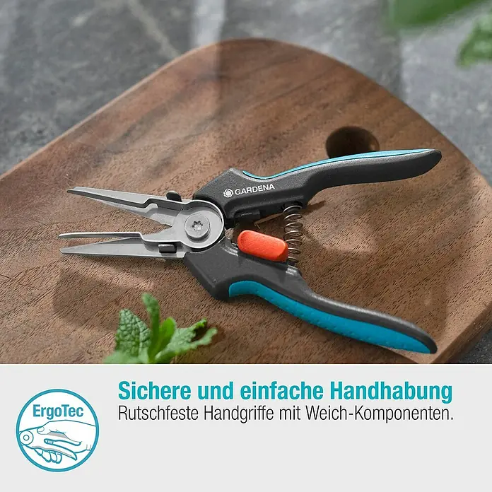 Gardena Schere GripCut - Länge: 15,6 cm - Nahaufnahme einer GARDENA Kräuterschere auf einem Holzbrett, die für präzise Schnitte im Garten konzipiert ist.