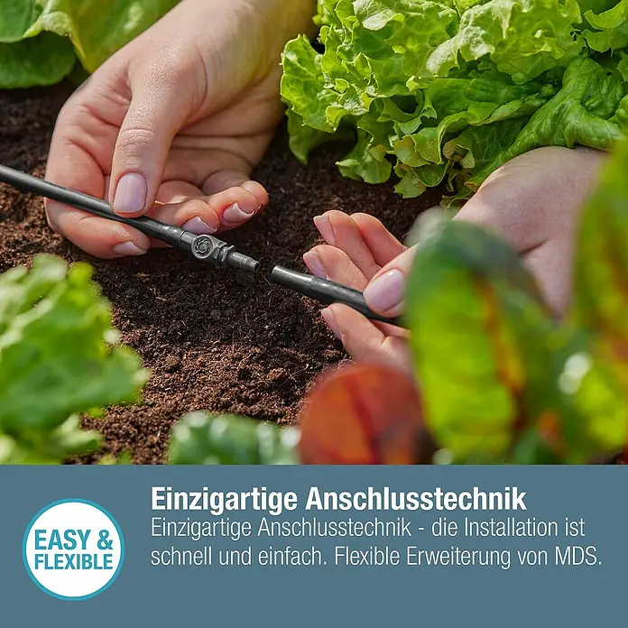 Gardena Micro-Drip Verbinder - 3/16" x 4,6 mm, 10 Stk. - Nahaufnahme einer Person, die ein Bewässerungssystem in einem Garten mit Salatpflanzen installiert.