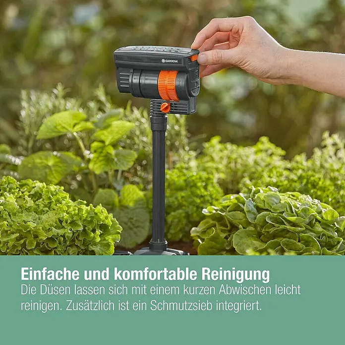 Gardena Micro-Drip Viereckregner OS 90 - Max. Regnerfläche: 90 m², Schwarz/Orange - Nahaufnahme eines GARDENA Sprinklers im Garten. Er ermöglicht eine einfache und komfortable Reinigung der Düsen.