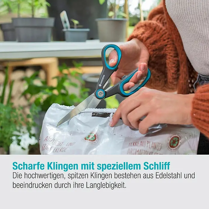 Gardena Universalschere MultiCut - Länge: 22,6 cm - Eine Person öffnet mit einer Gardena Gartenschere eine Tüte Pflanzerde. Die Schere hat blaue Griffe und silberne Klingen.