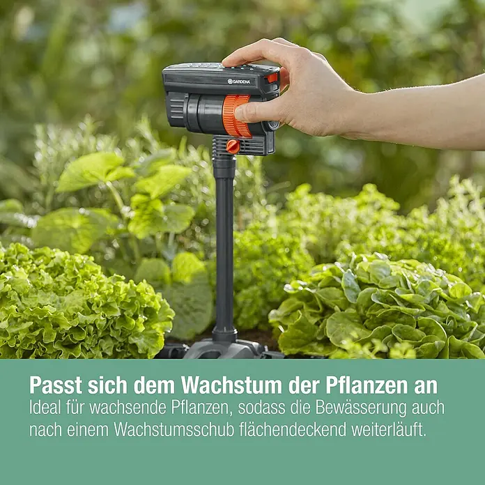 Gardena Micro-Drip Verlängerungsrohr für OS 90 - 2 Stk., Länge: 20 cm - Das Bild zeigt einen GARDENA Vielflächenregner, der im Garten zwischen Pflanzen steht und von einer Hand bedient wird.