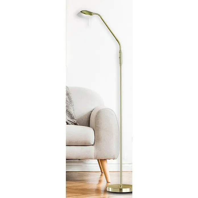 Fischer & Honsel Pool LED-Stehleuchte - 5 W, Höhe: 160 cm, Messing, Mehrfarbig - Eine goldene Stehlampe mit verstellbarem Kopf steht neben einem beigen Sessel und beleuchtet den Raum mit ihrem warmen Licht.
