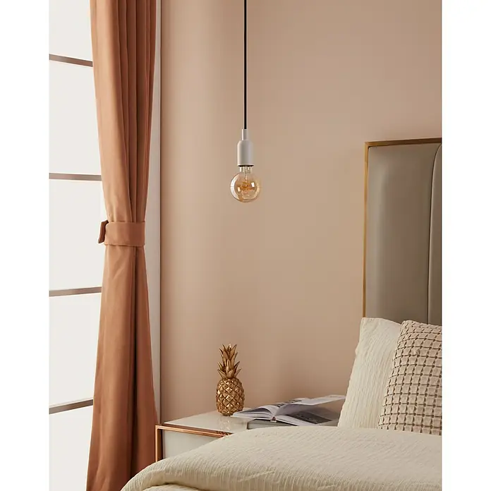 Eglo connect.z Smart-LED-Lampe Vintage Globe-Form E27 - E27, Dimmbar, Warmweiß, 400 lm, 4,9 W - Nahaufnahme einer Glühbirne, die von der Decke hängt und ein weiches, warmes Licht in einem Schlafzimmer spendet.