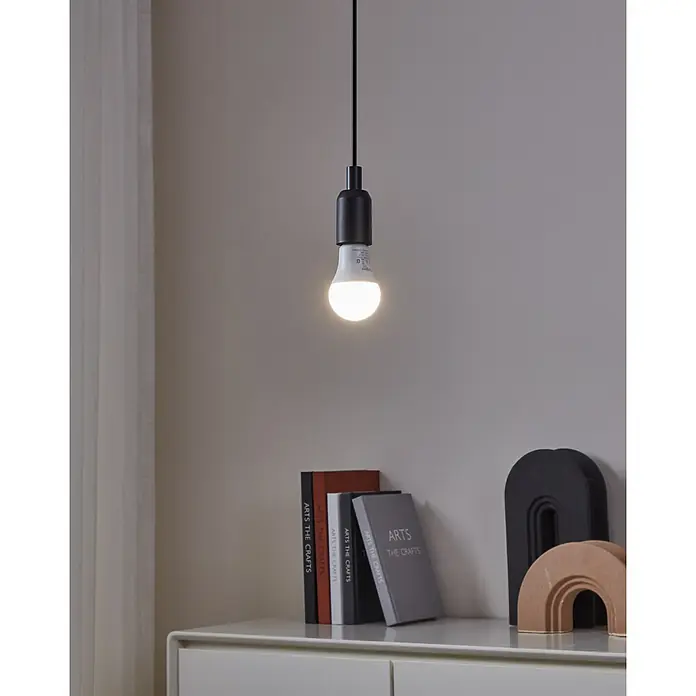 Eglo connect.z Smart-LED-Lampe Zigbee RGB/CCT - E27, Dimmbarkeit: Dimmbar, RGBW, 806 lm, 9 W - Nahaufnahme einer modernen Hängelampe mit einer LED-Glühbirne, die ein helles Licht ausstrahlt, vor einem Bücherregal.