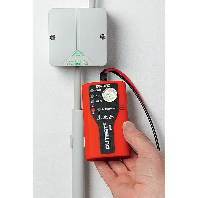 Benning Leitungsprüfer & Durchgangsprüfer Dutest Pro - 6 V - 400 V - Nahaufnahme eines BENNING DUTEST® pro Spannungsprüfers, der an einer Wand montiert ist. Das Gerät zeigt Widerstands- und Spannungsprüfungen an.