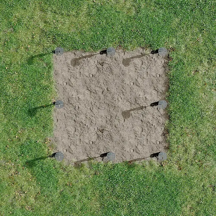 SunElements Gewächshaus-Fundament 5.2 - Passend für: Sun Garden Gewächshäuser Select, Infinity & Energy in der Größe 5.2 - Quadratischer, ebenerdiger Bereich mit acht schwarzen Pfostenankern. Der Bereich ist von grüner Wiese umgeben.