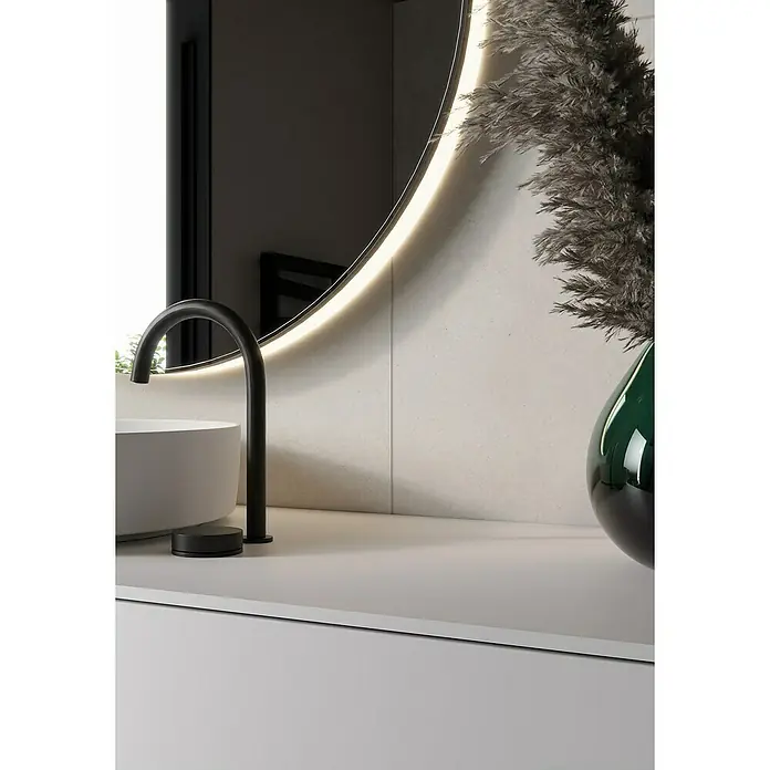 Feinsteinzeugfliese Big Ivory - 60 x 60 cm, Hellbeige, Matt - Ein runder Spiegel mit einem schwarzen Hahn und einer grauen Vase. Zeitgenössisches Badezimmer-Design mit Beleuchtung.