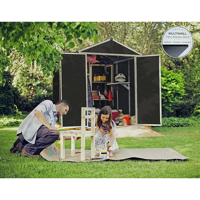 Palram – Canopia Gartenhaus Rubicon - Außenmaß inkl. Dachüberstand (B x T): 1,85 x 3,78 m, Kunststoff, Grau - Ein geräumiges Gerätehaus mit geöffneten Türen im Garten, während ein Vater und seine Tochter einen Holzstuhl bemalen.